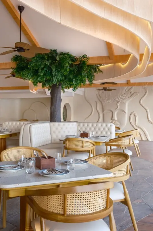 Restaurant interior with tree centerpiece and decorative wall art