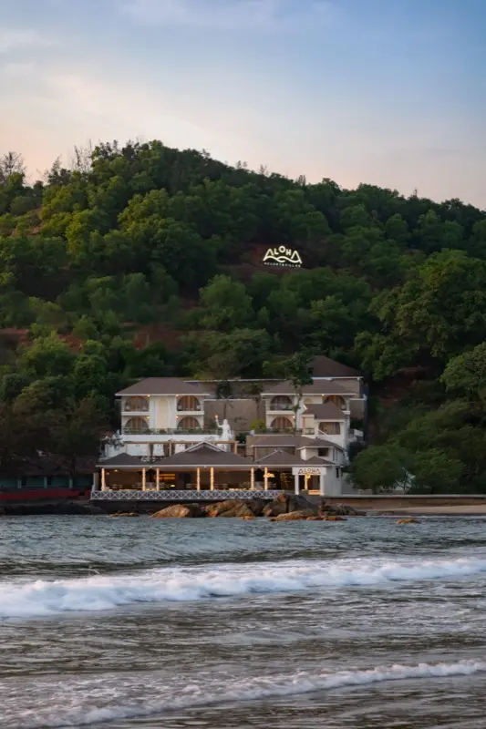 Intimate dining corner with tropical leaf wall relief and pendant light
