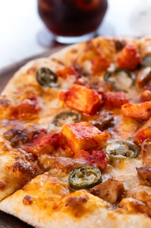 Close-up pizza with jalapenos, paneer and melted cheese