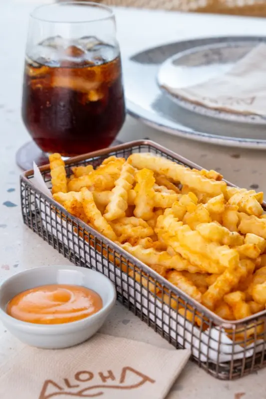 Crispy crinkle fries with dipping sauce on Aloha napkin