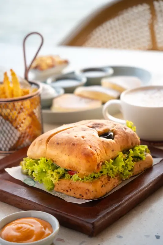 Gourmet sandwich with fries and cappuccino