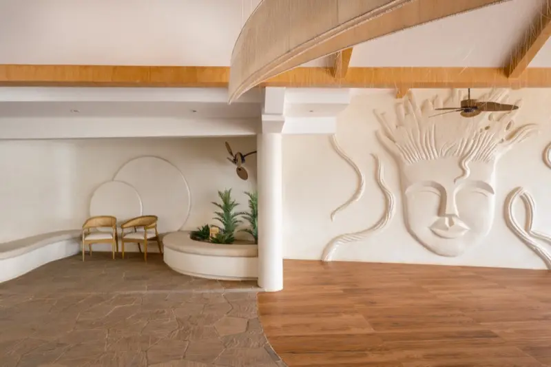 Interior lounge with decorative face wall relief and wooden floors