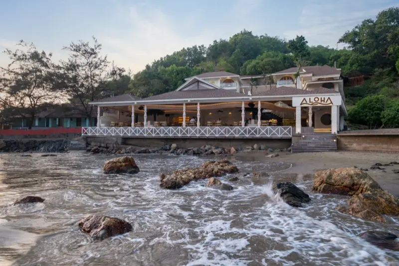 Cafe Aloha beachfront exterior with ocean rocks and waves