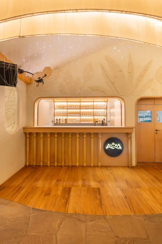 Aloha bar with illuminated shelves and tropical leaf ceiling art