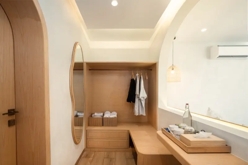 Wardrobe area with oval mirror, towels and pendant light
