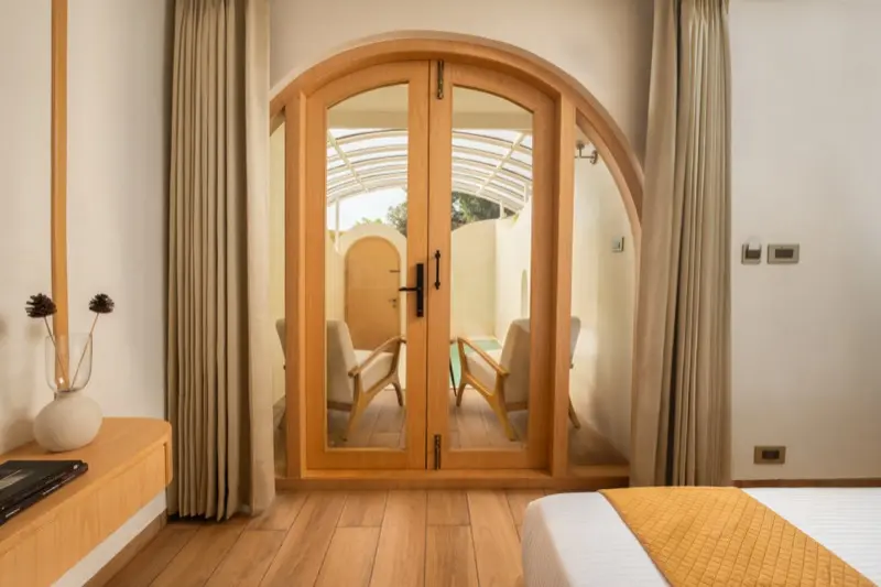 Arch door opening to private pool villa outdoor patio