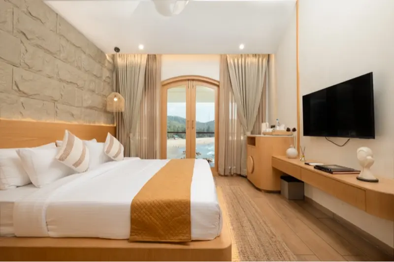 Premium room with stone accent wall and ocean-view arch window