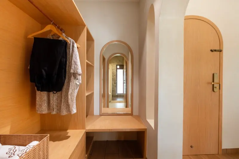 Wardrobe with arched mirror and hallway to bathroom